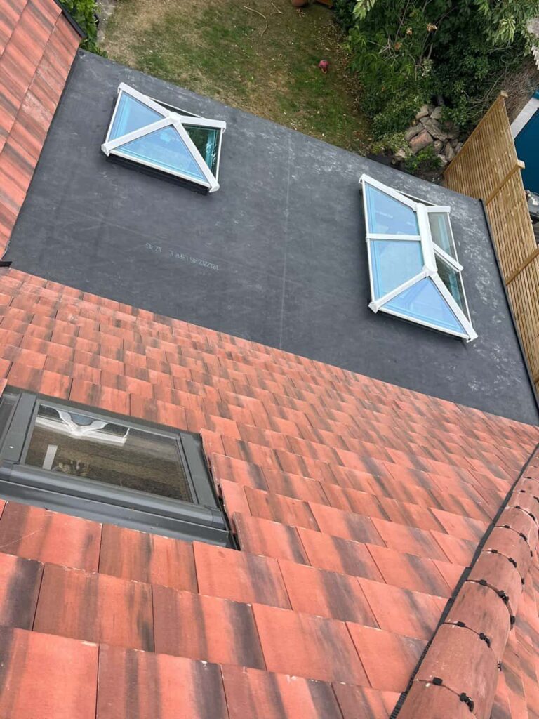 This is a photo taken from the roof ridge looking down a tiled pitched roof on to a flat roof. Works carried out by LJ Roofing Abingdon